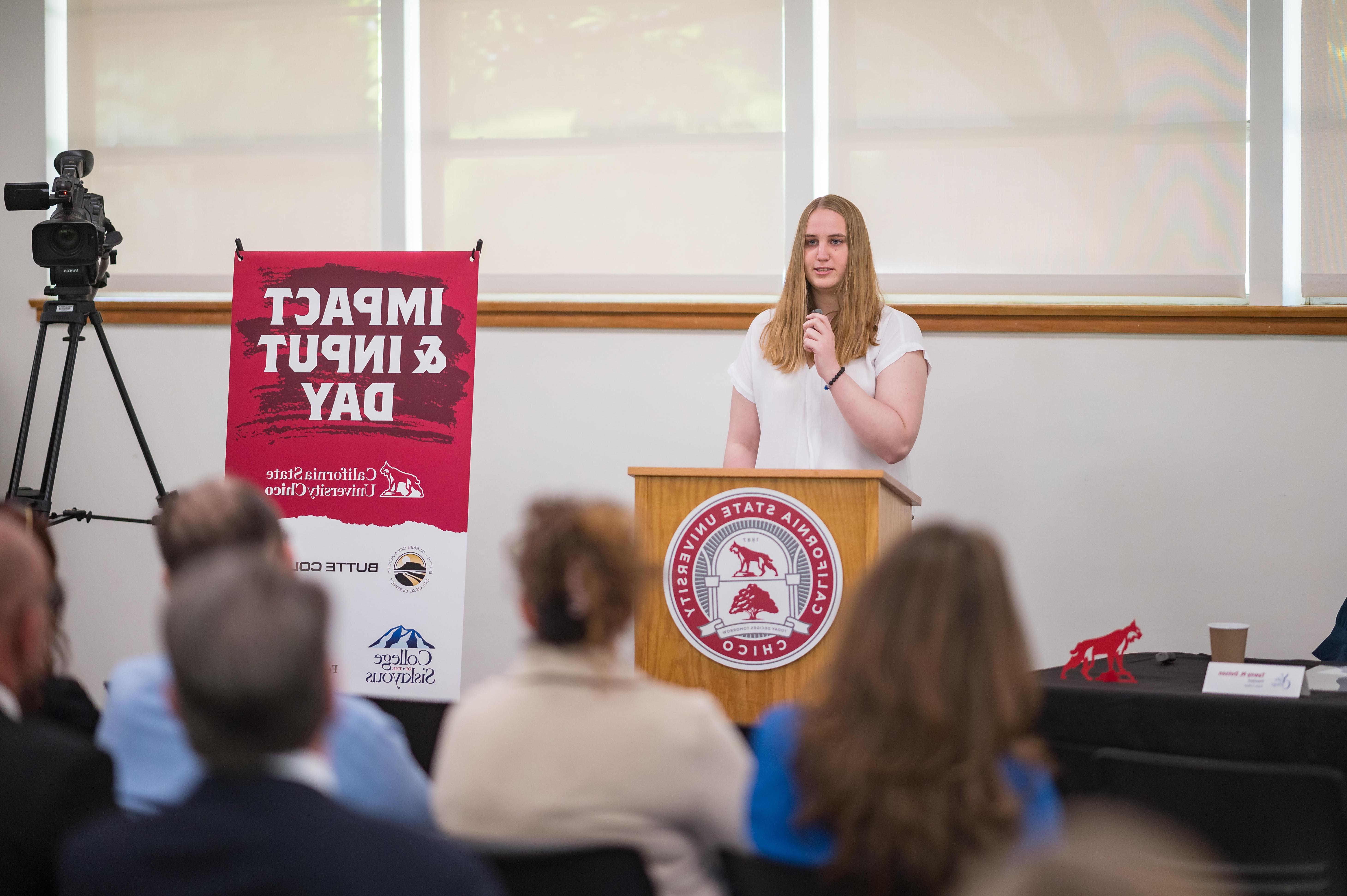 A 太阳城娱乐 transfer student is show speaking at a podium.